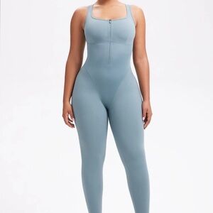 She’s waisted green, one piece compression jumpsuit